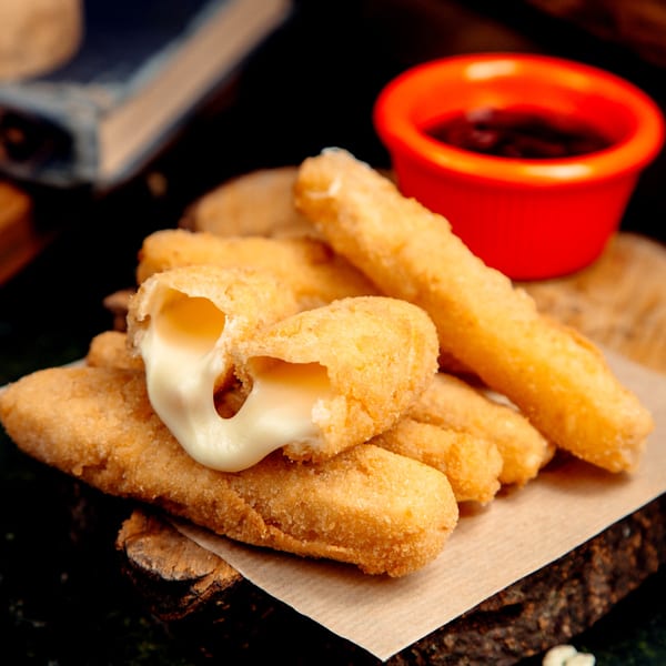 Golden-brown mozzarella sticks with melted cheese oozing out, served with a red dipping sauce.